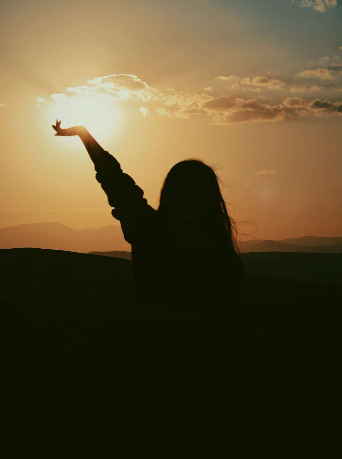 Woman reaching toward the sunrise — psychotherapy for lasting healthy habits at The Design Your Life Centre, Toronto.
