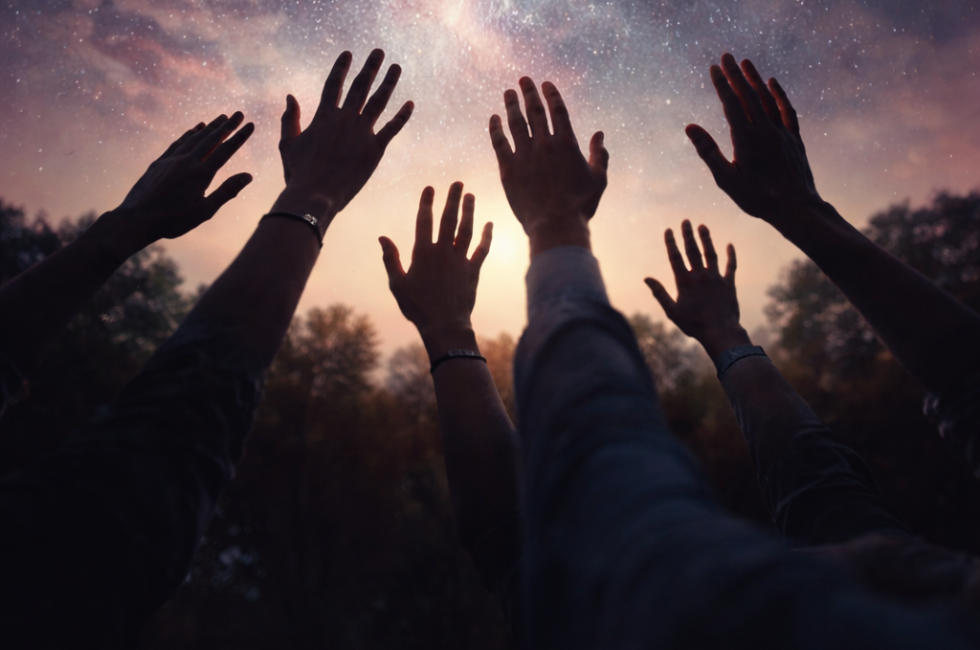 Silhouetted hands reaching upward toward a star-filled night sky, symbolizing collective intention, unity, and shared human potential.